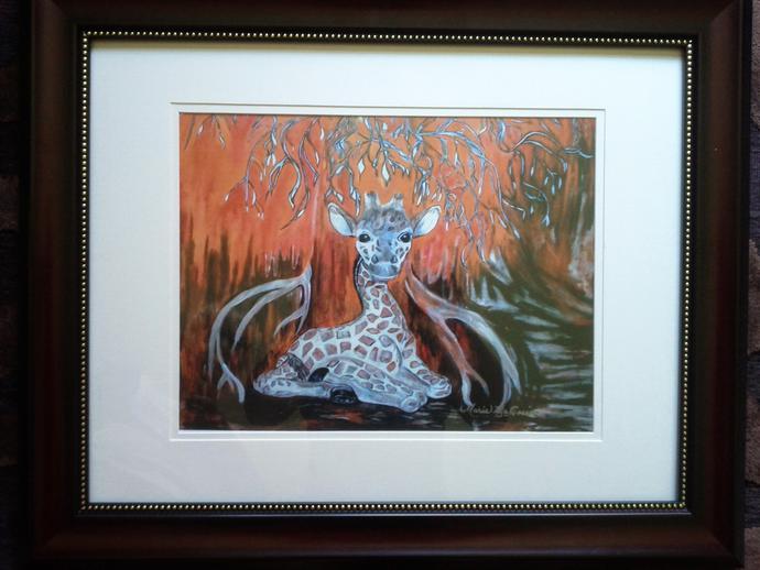 Framed artwork of a baby giraffe laying under a tree